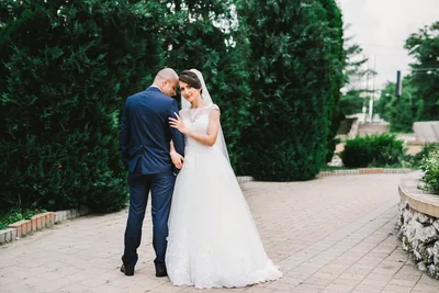 Bride and groom embracing on a garden path