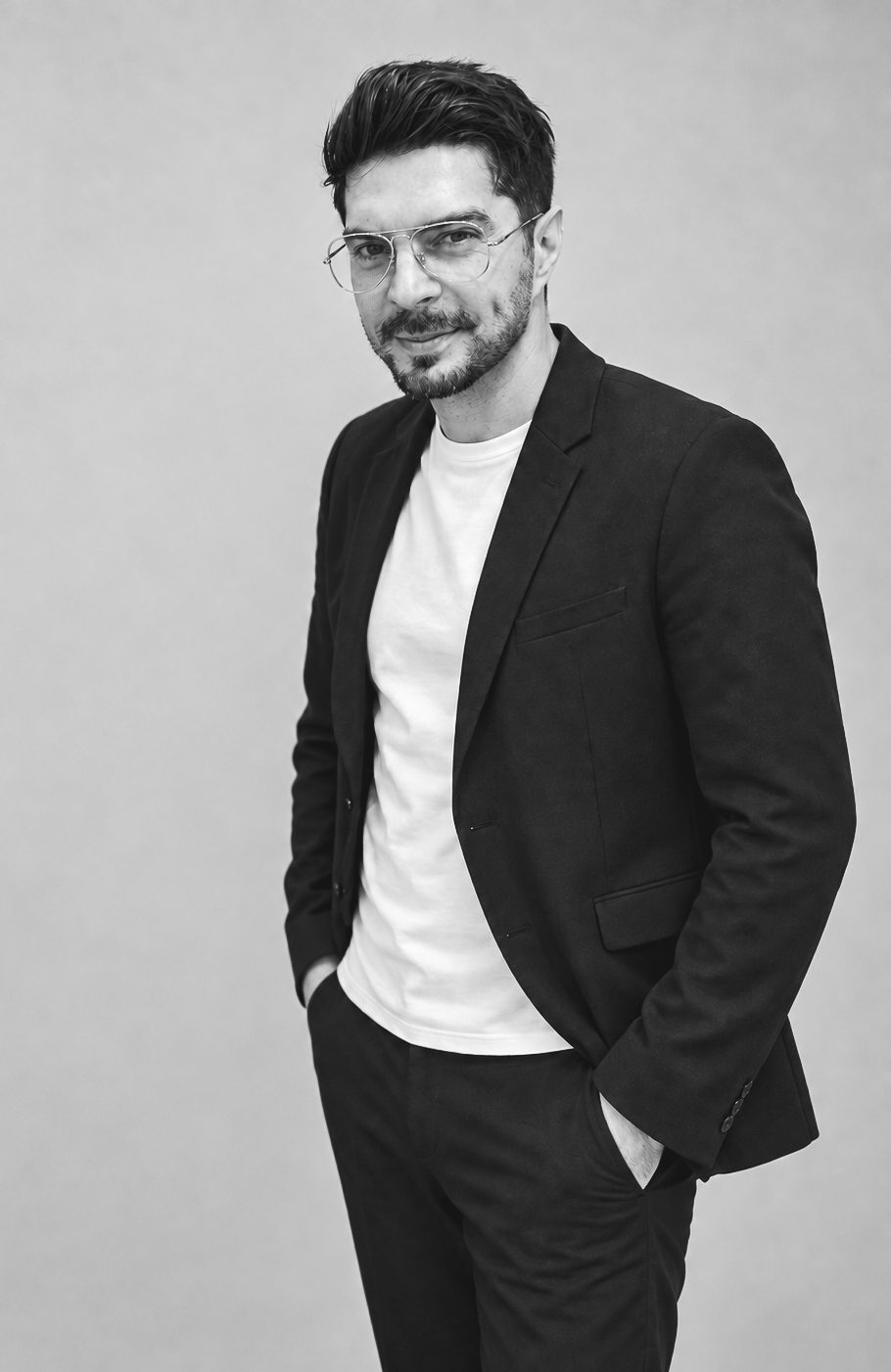Black-and-white studio portrait of Alex Claudio